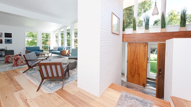 A spacious living room with a high ceiling, large windows, and a wooden staircase leading to an outdoor area. - Mid Century Mtn Home and a cabin on 3 acres - 10 Min to DGO - AC-Hot Tub (Durango)