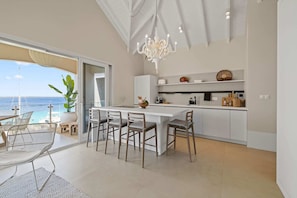 Enjoy meals and gatherings in this spacious dining area with a view of the sea.