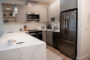 Una cocina moderna con una isla grande, electrodomésticos de acero inoxidable y un diseño minimalista.