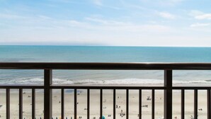 A beach view from a balcony with a railing, sandy beach, and ocean. - Sky-High Luxury Retreat: King Ste on the 15th Flr (Myrtle Beach)