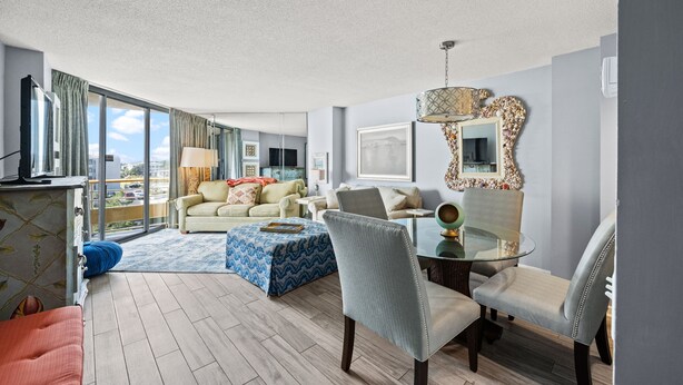 A modern living room with a sofa, armchairs, a glass coffee table, and a large mirror. - Recently Renovated Oceanfront Condo, Private Resort +Free Attraction Tickets! (Myrtle Beach)