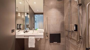 Une salle de bain moderne avec une douche, un lavabo et un miroir.