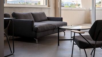 Una sala moderna con un sofá gris, una mesita y una silla.