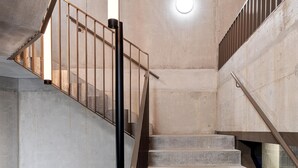 A concrete staircase with metal railings and a ceiling light. - Zleep Hotel Lausanne-Chavannes (Chavannes-près-Renens)