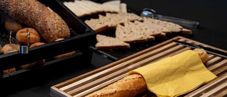 Diverse pagnotte e dolci su assi di legno.