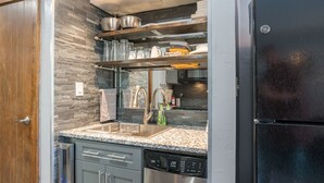 A modern kitchen with granite countertops, stainless steel appliances, and a built-in oven. - The Serenity Studio | AC, Pool, Hot Tub, Golf & Ski (Durango)