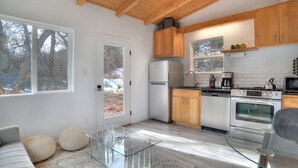 Una cocina moderna con armarios de madera, electrodomésticos de acero inoxidable y una mesa de comedor de vidrio.