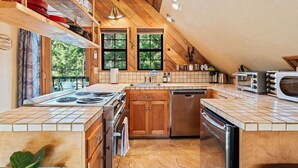 Una cocina moderna con armarios de madera, estufa, lavavajillas y tostadora.