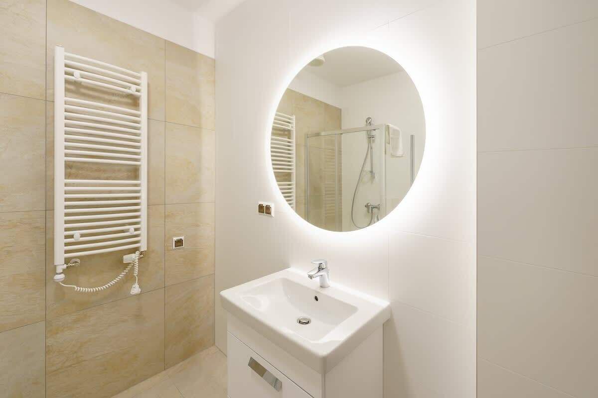 Een moderne badkamer met een ingebouwd toilet, een wastafel met spiegel en een douche.