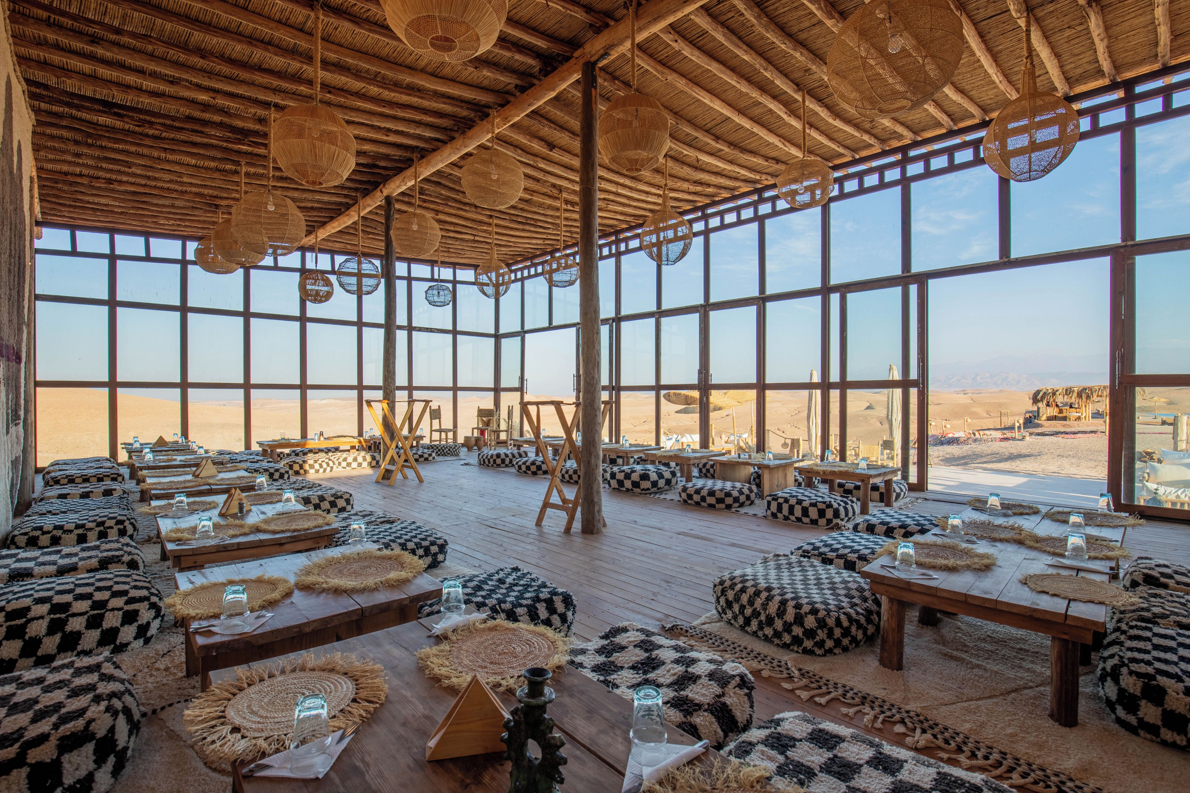 A spacious interior with high ceilings, large windows, and a desert view.