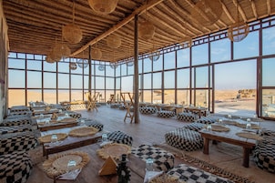 A spacious interior with high ceilings, large windows, and a desert view.