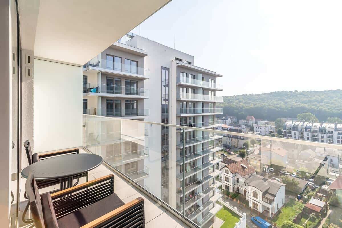 Ein Balkon mit Glasgeländer mit Blick auf eine Wohngegend.
