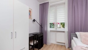 A bedroom with a bed, a desk, and a wardrobe. - Comfortable Apartment with Bedroom | Work Space (Gdańsk)