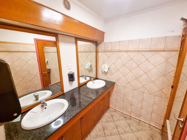 A bathroom with two sinks, a mirror, and a towel rack. - Unique City Hostel 100 meters from Beach (Larnaca)