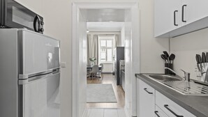 A modern kitchen with white cabinetry, a stainless steel refrigerator, and a built-in sink. - Stylish Apartments near AKH (Vienna)