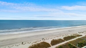 A beach with a clear sky and calm sea. - 8th Floor: 1 Bedroom Oceanfront Deluxe King Suite (Myrtle Beach)