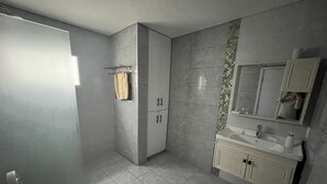 A modern bathroom with a toilet, sink, and mirror. - Casa Relax 3 (Paysandú)