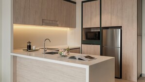 A modern kitchen with a central island, stainless steel appliances, and wooden cabinetry. - Citadines Waterfront Kota Kinabalu (Kota Kinabalu)