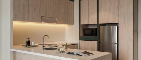 A modern kitchen with a central island, stainless steel appliances, and wooden cabinetry.