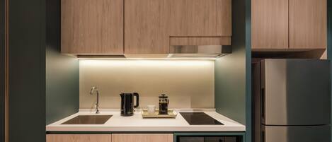 Una cocina moderna con armarios de madera, un lavamanos doble, una cafetera y un microondas integrado.