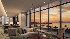 A modern hotel lobby with a large sofa, armchairs, a coffee table, and a view of the sunset over the water. - Citadines Waterfront Kota Kinabalu (Kota Kinabalu)