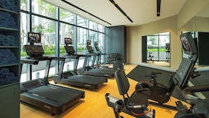 A modern gym with treadmills, stationary bikes, and exercise equipment. Large windows provide natural light and views of the outdoors. - Citadines Waterfront Kota Kinabalu (Kota Kinabalu)