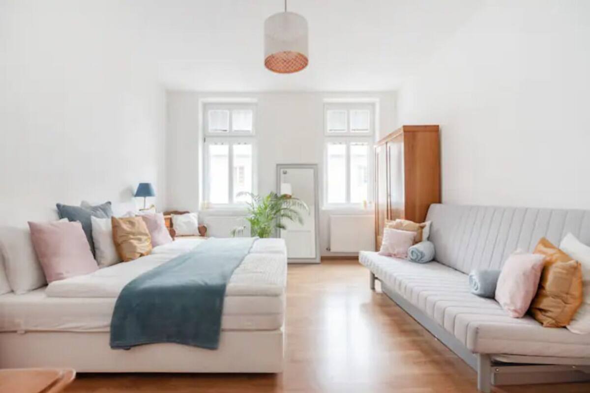 Un salon spacieux avec deux canapés, une table basse et une lampe.