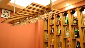 Eine Bar mit Holzböden, die verschiedene Flaschen beherbergen, und einem Deckenventilator.