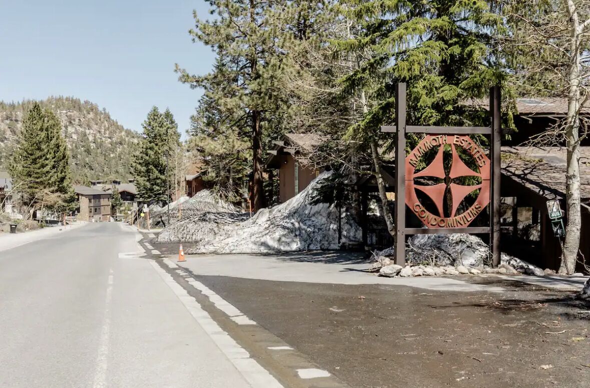 A sign for Mammoth Esthetics Condominium with a clear road in front.