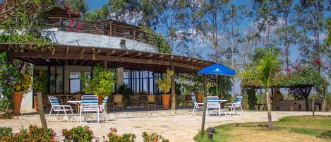 A two-story building with outdoor seating and a covered patio area.