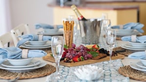 A table set for a meal with plates, cutlery, glasses, and a bottle of champagne. - Paradise Palms (Airlie Beach)