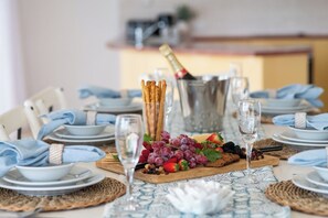 Ett dukat bord för en måltid med tallrikar, bestick, glas och en flaska champagne.