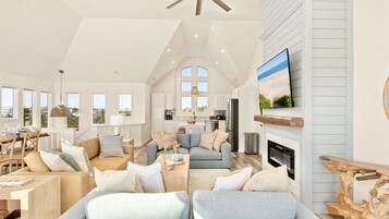 A spacious living room with a high ceiling, a fireplace, and a television mounted on the wall.