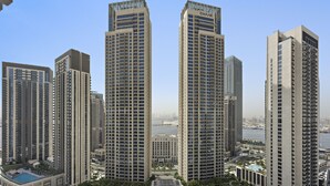 A high-rise building complex with multiple towers, a central courtyard, and a view of a body of water.
