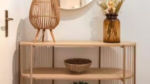 A wooden console table with a mirror, a wicker lamp, and a vase with flowers. - Designer Apartments - Near Reumannplatz (Vienna)
