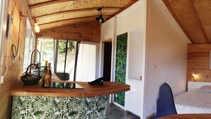 A wooden cabin interior with a dining area, a bed, and a window with a view. - Farm cottage with view of the Vercors 4 pers (Saint-Péray)
