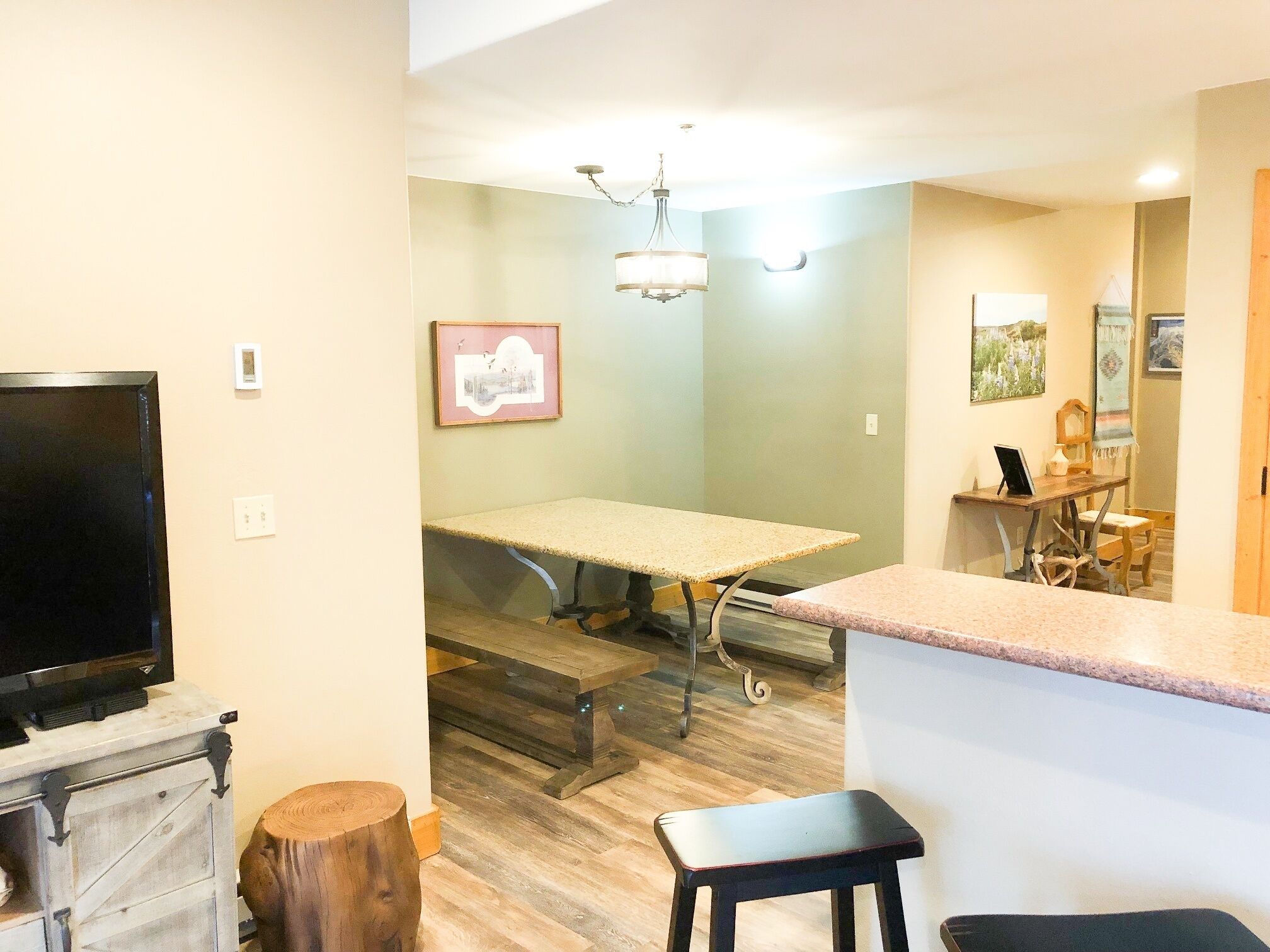 A compact living space with a television, a dining table, and a kitchen area.