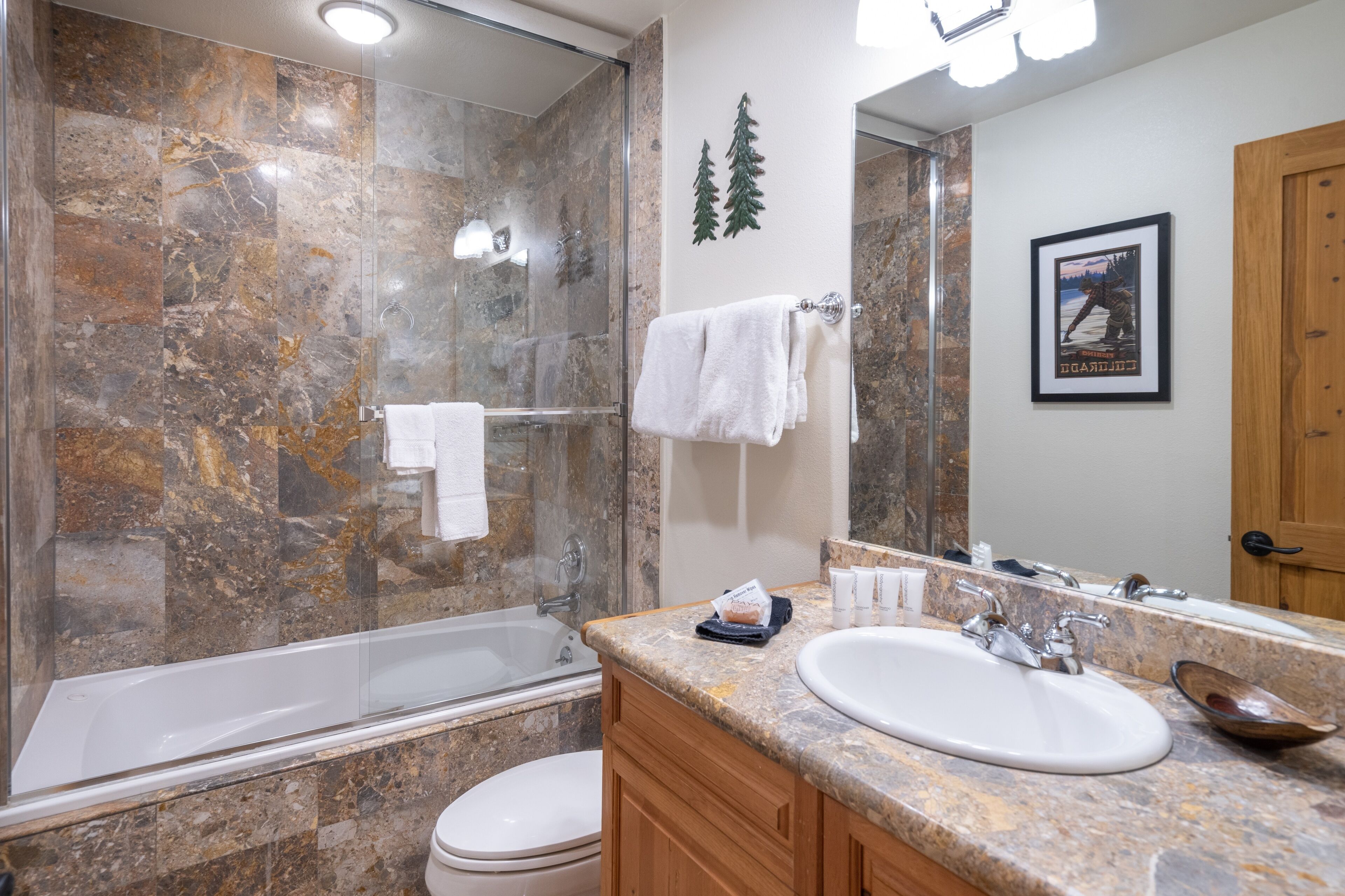 Un bagno con doccia vetrata, vasca, lavabo e water.