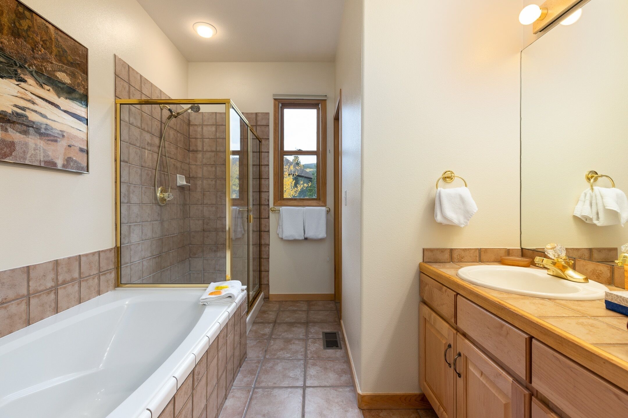 A bathroom with a bathtub, a shower, a sink, and a mirror.