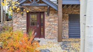 A stone building with a dark brown door, numbered 1952, and a garage door to the right. - 1952 Northstar 3 Bedroom Townhouse by RedAwning (Keystone)