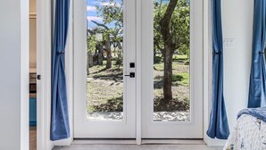 A double door with a view of a tree-lined outdoor area.