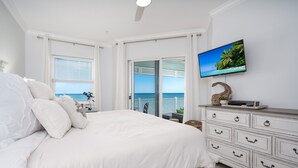 A bedroom with a large bed, a television on the wall, and a view of the ocean through the window. - Luxury 5th floor oceanfront condo 754 at Cinnamon Beach! (Palm Coast)