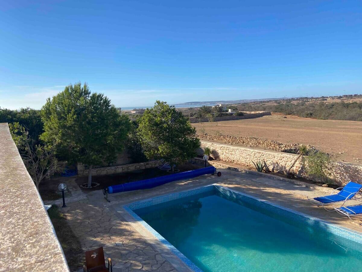Une piscine offrant une vue dégagée sur le paysage environnant, notamment sur les arbres et les collines au loin.