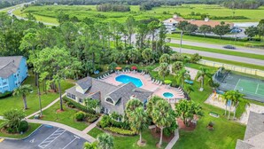 A large house with a swimming pool, tennis court, and a parking lot. - 	Resort-Style 3BR Condo (Kissimmee)