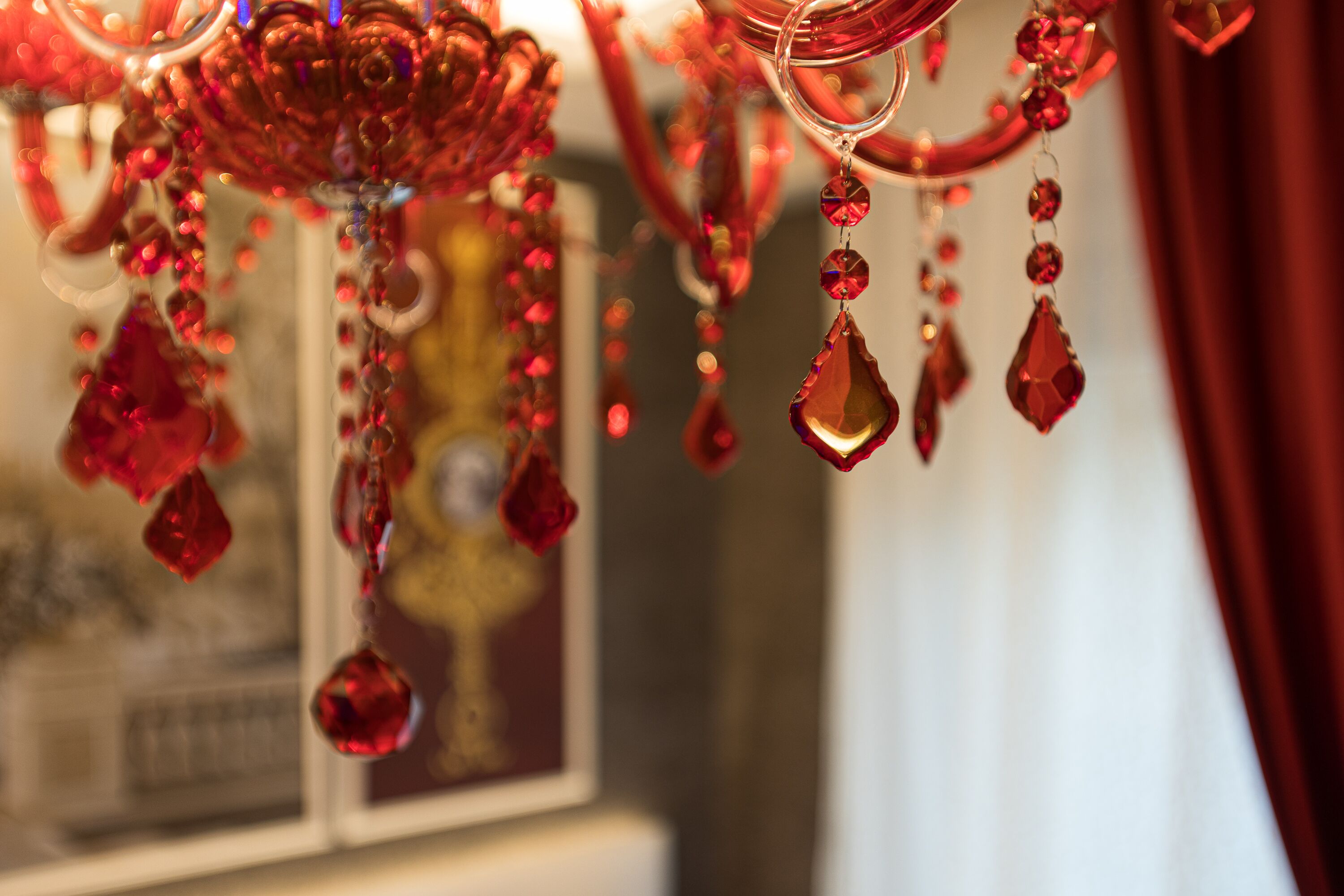 A close-up of a chandelier with red crystal decorations.