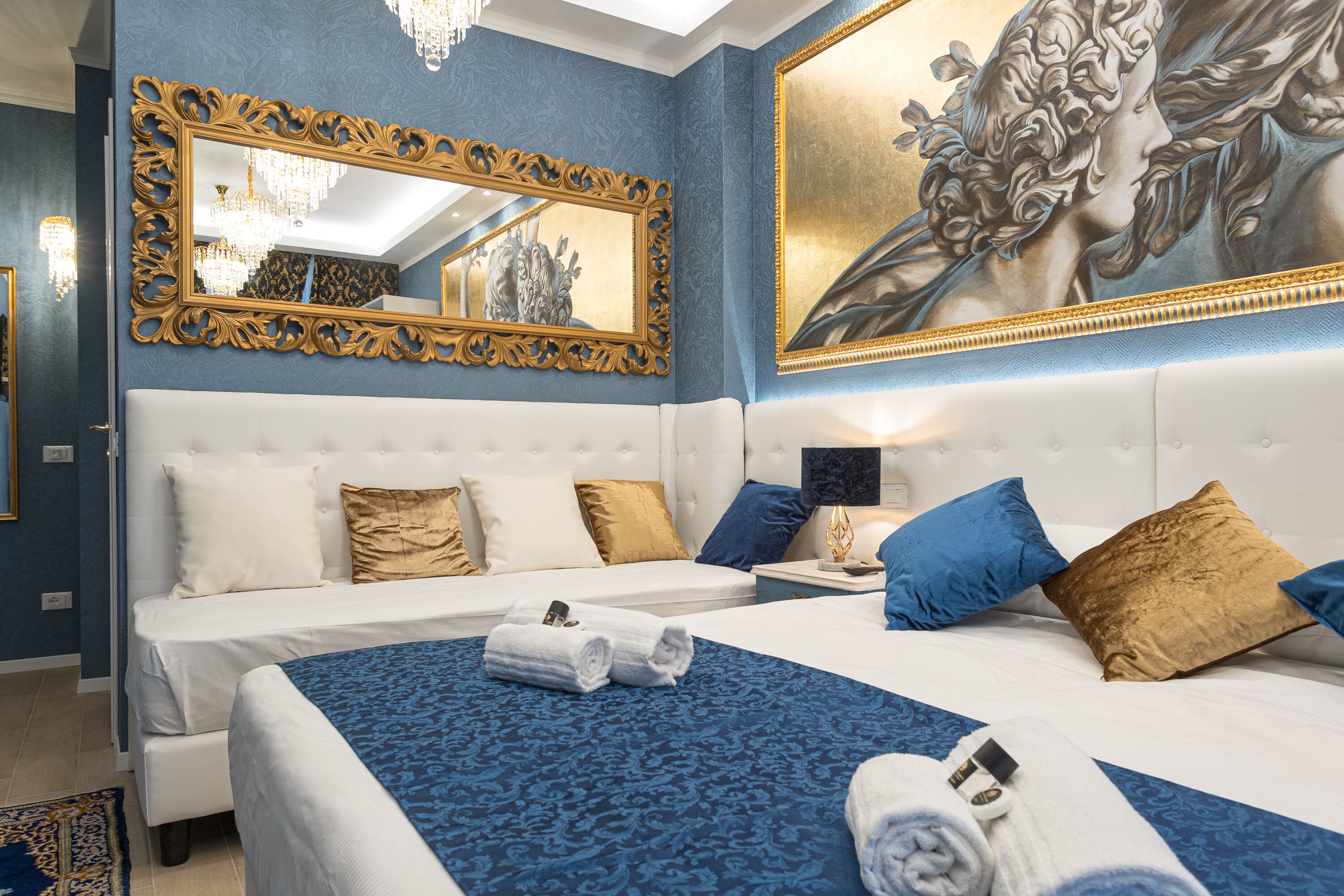 Habitación de hotel con dos camas, un espejo grande y un cuadro en la pared.