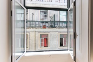 A view from a balcony with a patterned exterior wall, a metal railing, and a potted plant. - Downtown Design by Homing (Lisbon)