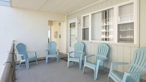 Katettu ulkotila, jossa on vaaleansiniset Adirondack-tyyliset tuolit aseteltuna puoliksi ympyrän muotoon.