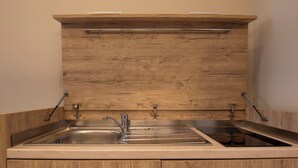 A kitchen with two stainless steel sinks, wooden cabinetry, and a wooden countertop. - HOTEL AD Suites Nazionale (Rome)