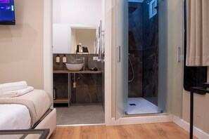 Habitación económica | Baño | Regadera, regadera tipo lluvia, secadora de cabello, pantuflas 